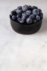 Frozen blueberrys in a black ramekin