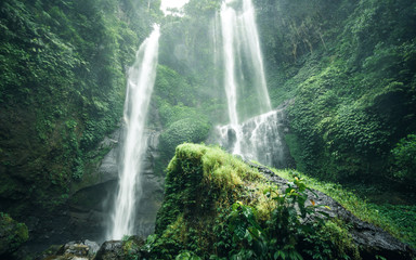 Panoramic landscape view of  Sekumpul waterfall in Bali surrounded by tropical forest