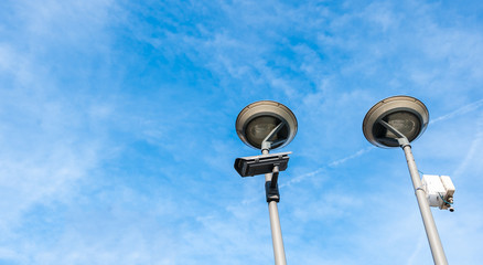 City cctv security surveillance camera system attached on the traffic light pole with clear blue sky background