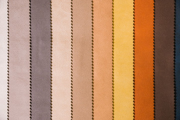 Colorful and bright fabric samples of leatherette furniture and clothing upholstery. Close-up of a...