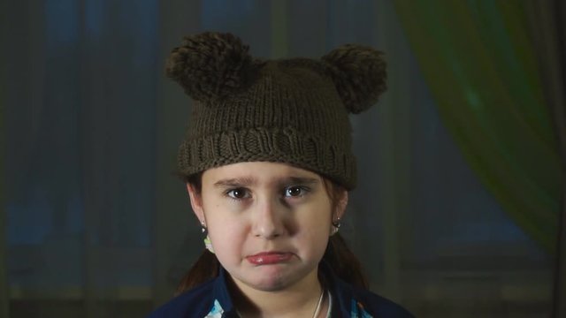 the girl in a cap with pompons makes ridiculous faces