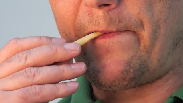 big mouth lips. man eating french fries.