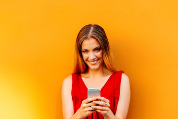 Portrait of beautiful young woman using mobile phone in the street.