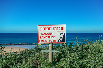 sign that warns about the danger ahead of dubbed the Hebrew inscriptions