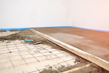 Builder worker plastering concrete at floor of house construction