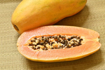 ripe papaya tropical fruit half cut on bamboo mat