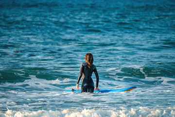 12/18/2018 Netanya, Israel, a surfer with a board goes swimming in the ocean at the dawn of the day