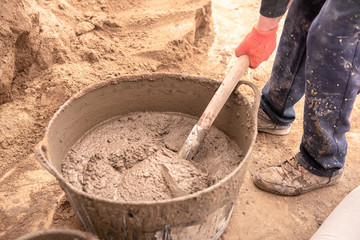 Mason kneads cement mortar for pouring concrete screed