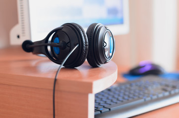 Plakat Big black headphones lie on the wooden desktop of the sound designer