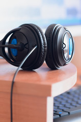 Obraz na płótnie Canvas Big black headphones lie on the wooden desktop of the sound designer