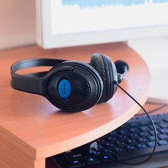 Plakat Big black headphones lie on the wooden desktop of the sound designer