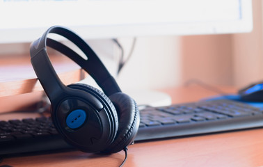 Naklejka na ściany i meble Big black headphones lie on the wooden desktop of the sound designer