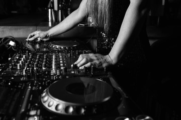 Hands of female DJ adjusting sound during disco party. Entertainment concepts equipment 