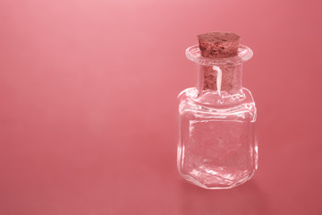 8794433 Empty small bottle with a cork on a living coral background with an empty inscription copy space. soft light