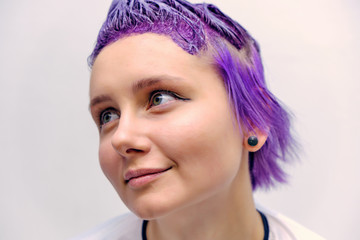 Beautiful girl with violet hair on white background master in make-up.
