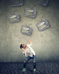 Multiple TV sets falling on a strssed scared man