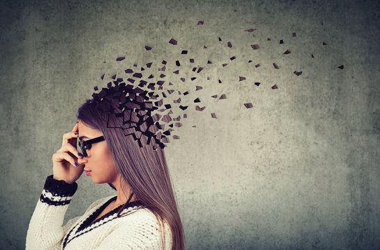 Memory loss due to dementia or brain damage. Side profile of a woman losing parts of head as symbol of decreased mind function.