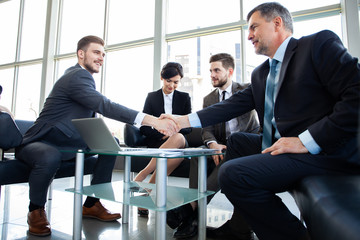 Business people shaking hands, finishing up a meeting. - obrazy, fototapety, plakaty