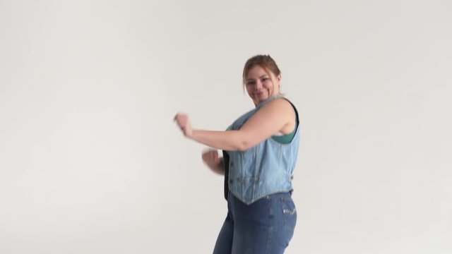 Beautiful fat woman dancing and having fun on studio background