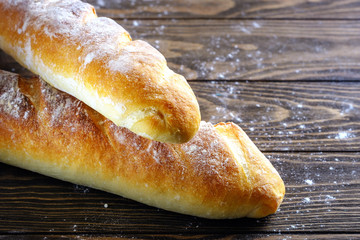 Fresh French loaf with a ruddy crust on a wooden table