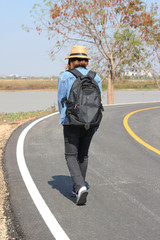 Girl in hat with backpack traveling on road, Travel concept.