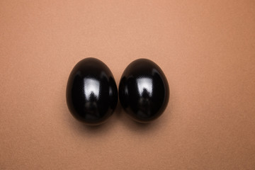 Black eggs on brown background close up