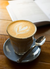 Hot coffee in glass cup with book.