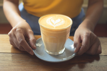 Woman holding coffee cup in hand.