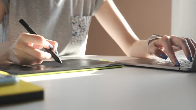Graphic designer working with digital drawing tablet and pen on a computer