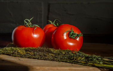 red tomatoes with dill on a wooden board. Home cooking