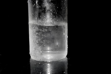 Splash of water on black, Stylish water splash. Isolated on black background, bubbles in the glass, the fog on the glass, water poured into the vessel