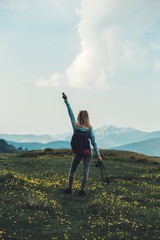 Girl  on top of a mountain watching a beautiful landscape with arm wide open.Success Concept