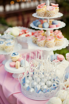 Candy bar with blue, pink and white cupcakes, macaroons and cake pops