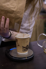 barista weighing coffee on scales