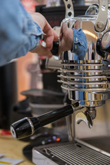 Barista making coffee in coffee machine