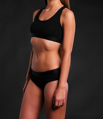 Naklejka premium sexy Fitness body in sport underwear on black background 