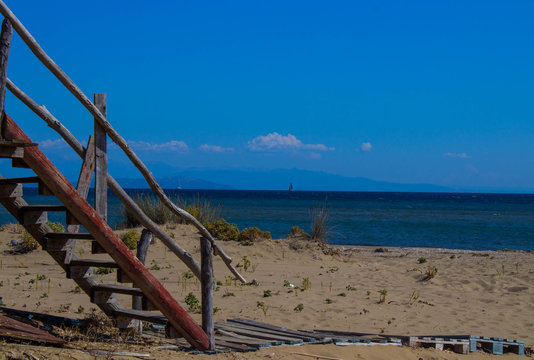 wooden stair on a sandy beach cabon near the ocean summer day