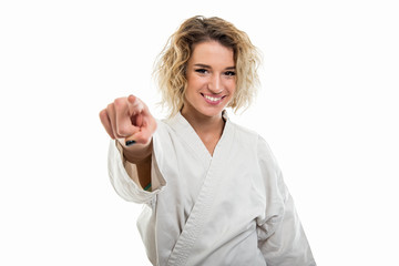Portrait of young female wearing martial arts uniform pointing camera © Catalin Pop