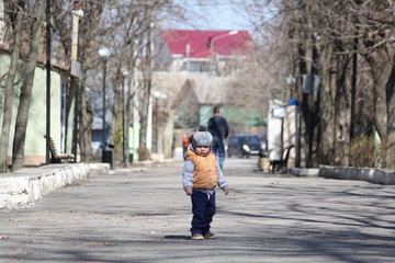 Cute child standing on the path in the spring park