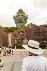 Young woman in beautiful hat is looking on Garuda Wisnu Kencana GWK statue