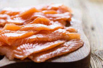 Smoked salmon on wooden board, sliced