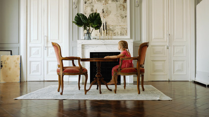 Little cute girl sitting at the table and wait
