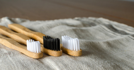 Three family Bamboo toothbrushes on grey textile  background. copy space for text