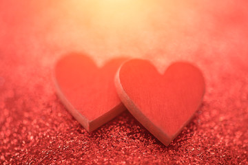 Two red hearts on glitter background in love concept