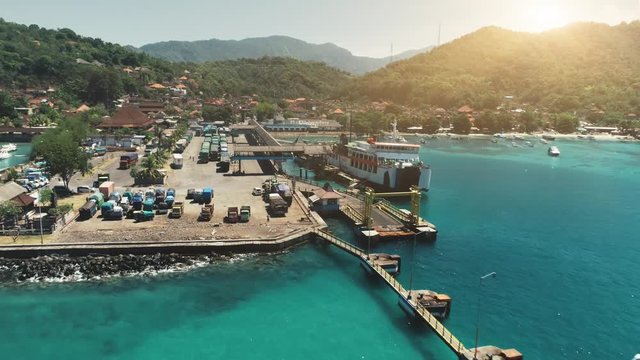 Aerial Drone Flight Above Ocean Harbor, Port, Pier. Trucks waiting next ferry to another paradise island. Travel Transport Tourism. Tropical Bali Island, Indonesia. From Down to Top, Zoom Out, 4K