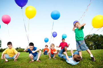 Group of Excited Boys with Balloons Outside