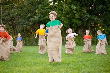 Happy Kids Having Potato Sack Race Outside - Powered by Adobe