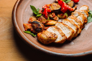 Chicken breast with grilled eggplants and peppers.