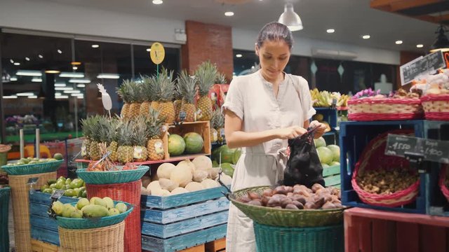 Zero Waste Concept: Young Woman Buying Fruits in Supermarket. No Plastic Bags, Healthy Vegan Lifestyle Footage. 4K Slowmotion. Bali, Indonesia.
