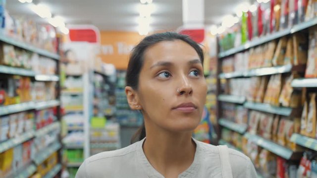 Young Mixed Race Girl Walking with Shopping Cart in Supermarket. Portrait of Attractive Woman Customer at the Shop. Consumerism Shopping 4K Slowmotion Concept.